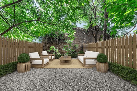 A backyard with a white couch and a coffee table.