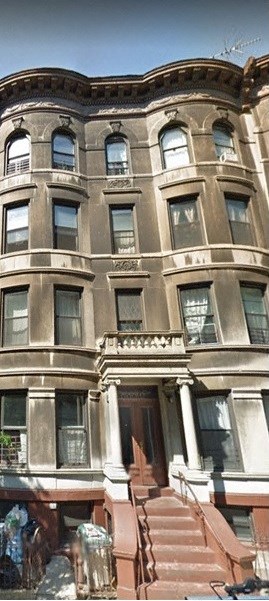 A large, old building with a staircase leading to the front door.