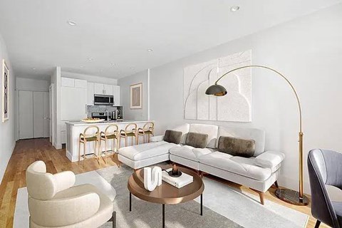 A modern living room with a white sofa, a coffee table, and a dining table with chairs.