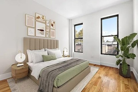 A bedroom with a large bed and a potted plant.