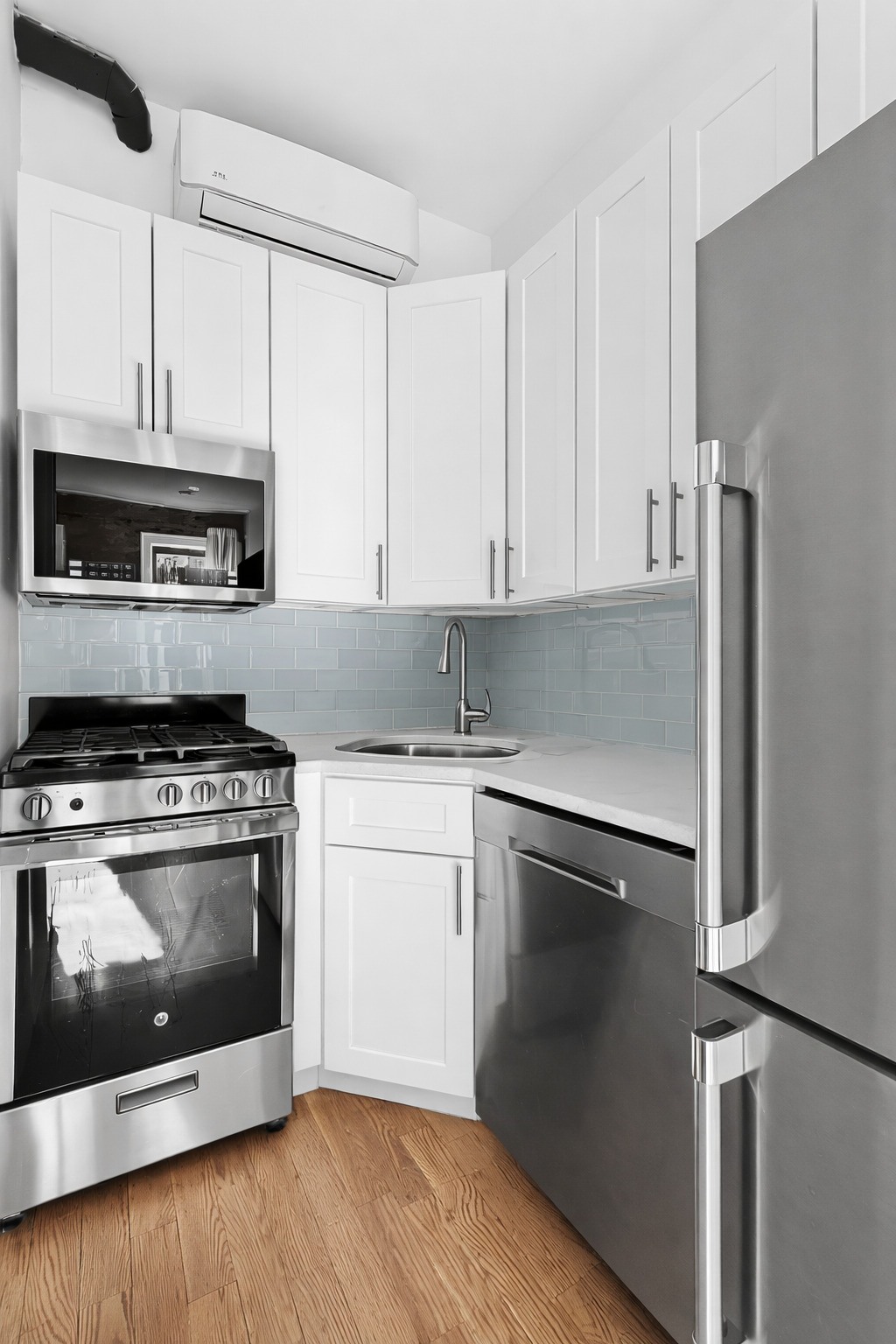 A modern kitchen with stainless steel appliances and white cabinets.