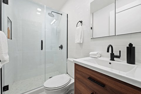A white toilet sits next to a sink in a modern bathroom.