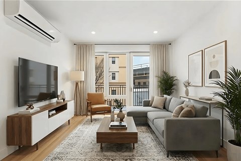 A modern living room with a grey couch, a wooden coffee table, and a flat screen TV mounted on the wall.