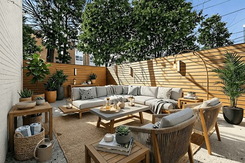 A patio with a couch, chairs, and a table with a potted plant on it.