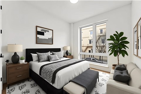 A bedroom with a large bed, a couch, and a plant.