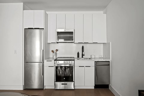 A modern kitchen with white appliances and cabinets.