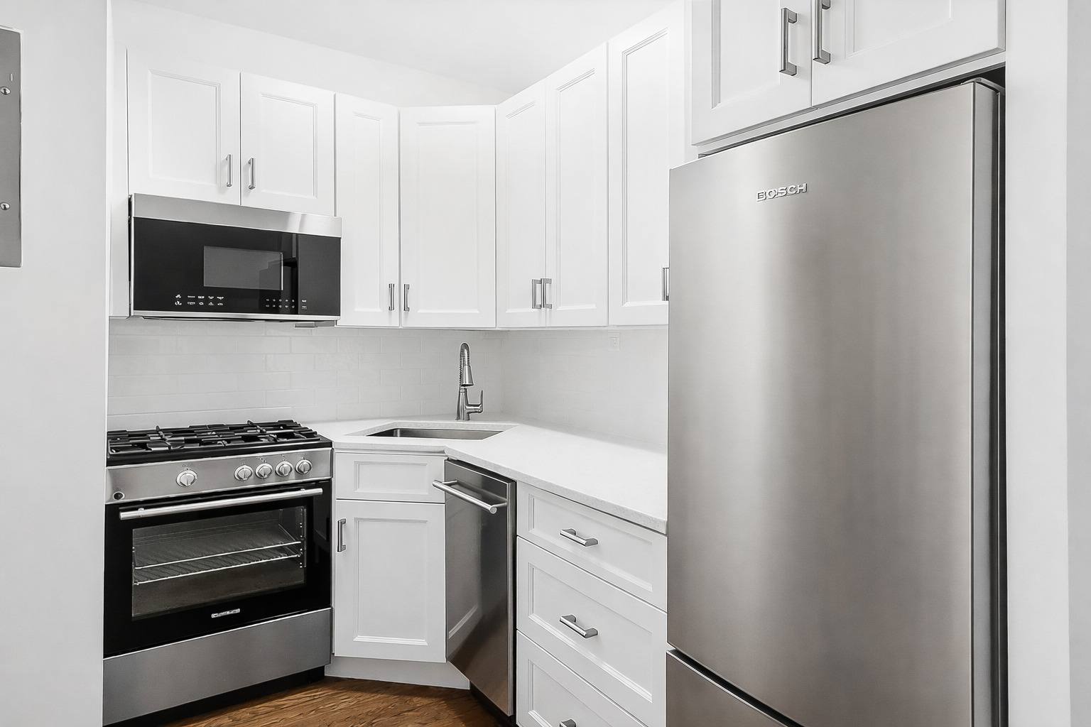 A kitchen with a stainless steel refrigerator, oven, and microwave.