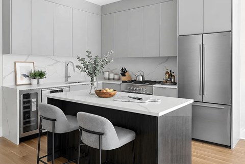 A modern kitchen with a marble backsplash and stainless steel appliances.