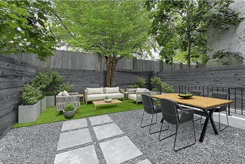 A patio with a table and chairs surrounded by a fence.