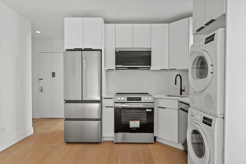 A modern kitchen with stainless steel appliances and white cabinets.