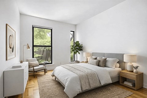 A bedroom with a large bed and a chair by the window.