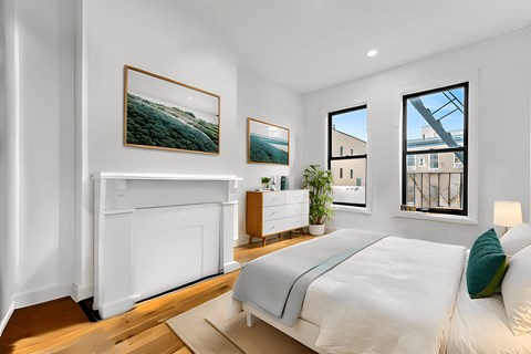 A bedroom with a large bed and a fireplace.