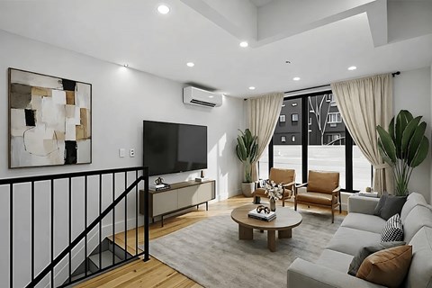 A modern living room with a flat screen TV, a coffee table, and a balcony with a railing.