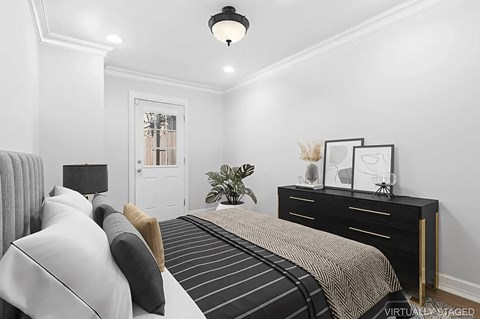 A bedroom with a bed, nightstand, and lamp.