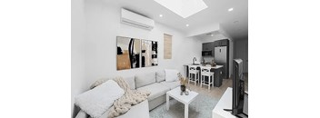 A living room with a white couch and a coffee table.
