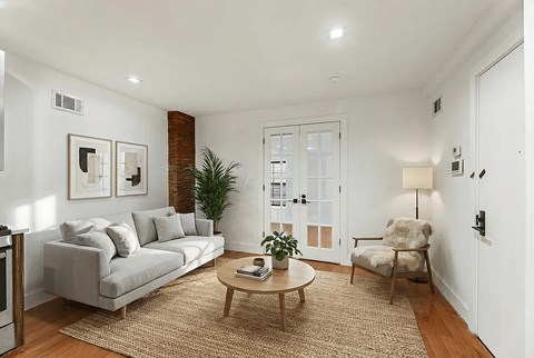 A living room with a grey couch, a wooden coffee table, and a chair.