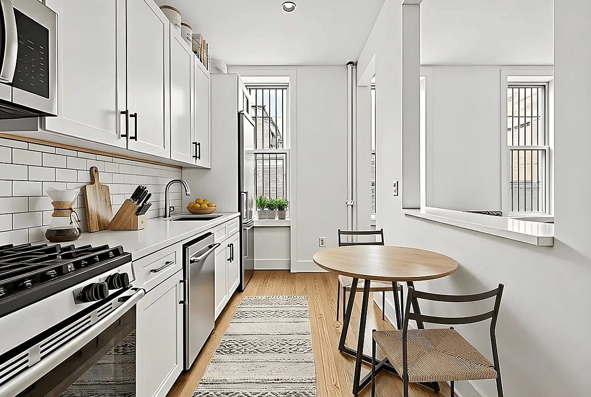 A kitchen with a stove, oven, and a table with two chairs.