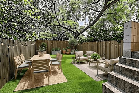 A backyard with a wooden fence and furniture.