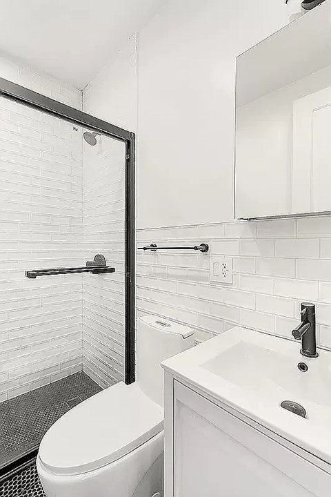 A white toilet sits next to a white sink in a bathroom.