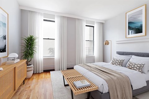 A bedroom with a large bed, a wooden nightstand, and a plant.