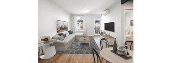 A living room with a grey couch and a painting on the wall.