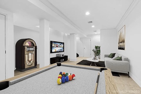 A pool table with a billiard ball on it in a room with a TV and a plant.