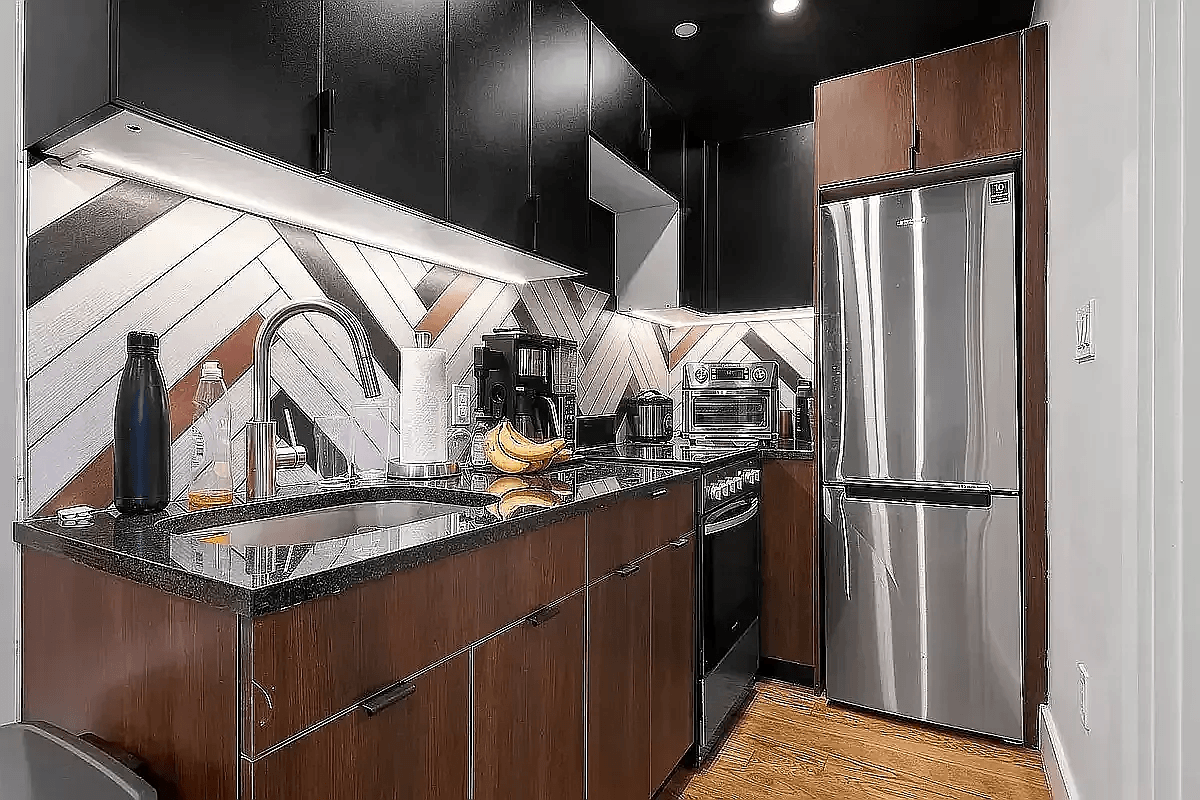A kitchen with a black counter top and wooden cabinets.
