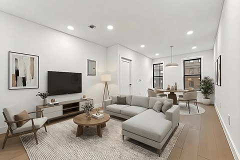 A modern living room with a grey sofa, wooden coffee table, and a flat screen TV.