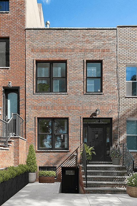 A red brick building with a black door and windows.