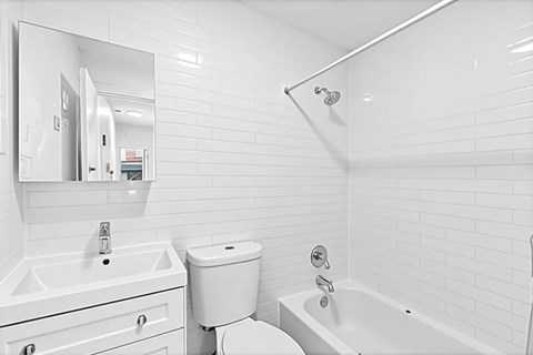 A white bathroom with a sink, toilet, and bathtub.
