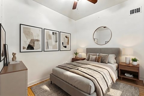 A bedroom with a bed, nightstands, and a ceiling fan.