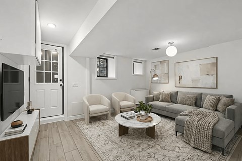 A living room with a grey couch, a coffee table, and a television.