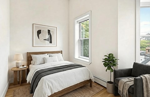 A bedroom with a bed, a chair, and a window.
