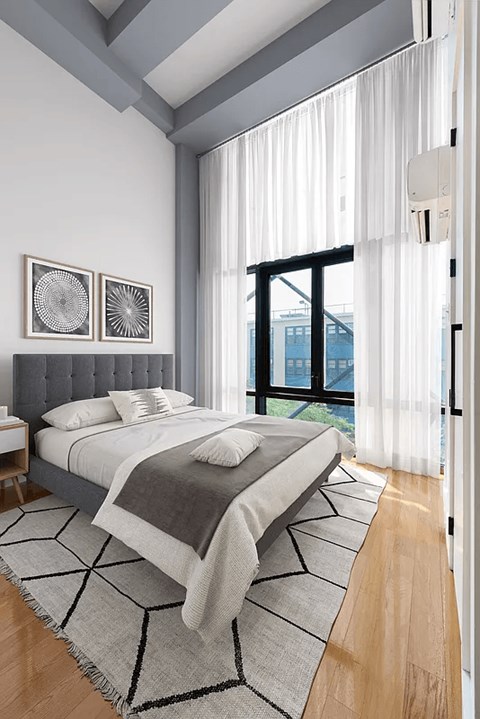 A bedroom with a large bed and a window overlooking a cityscape.