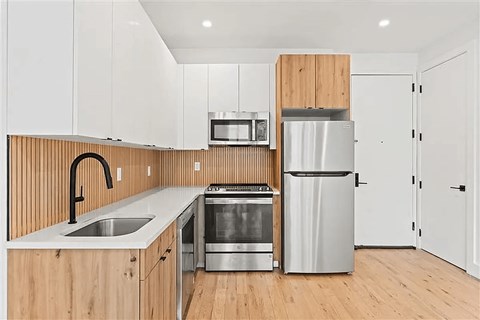 A modern kitchen with wooden cabinets and stainless steel appliances.