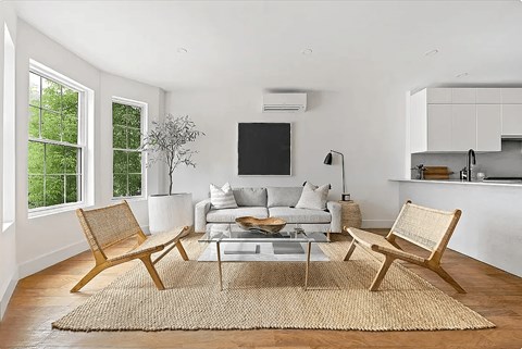 A living room with a couch, chairs, and a rug.