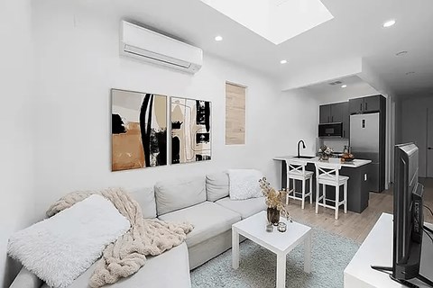 A living room with a white couch and a coffee table.