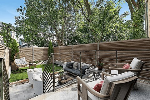 A patio with a table, chairs, and a grill.