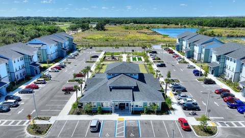 an aerial view of a parking lot with houses and a lake