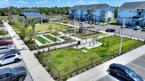 an aerial view of a park in the middle of a parking lot