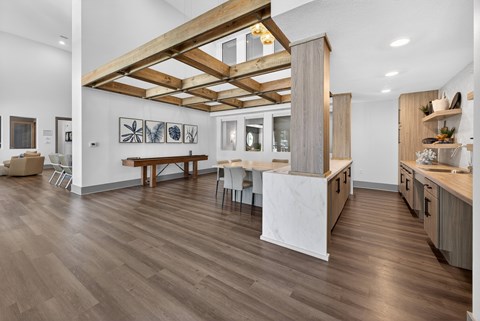 A kitchen with a wooden floor and a white wall.