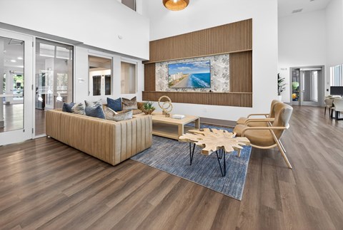 A living room with a wooden floor and a large painting on the wall.