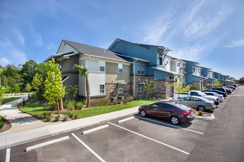 a row of houses with cars parked in front of them