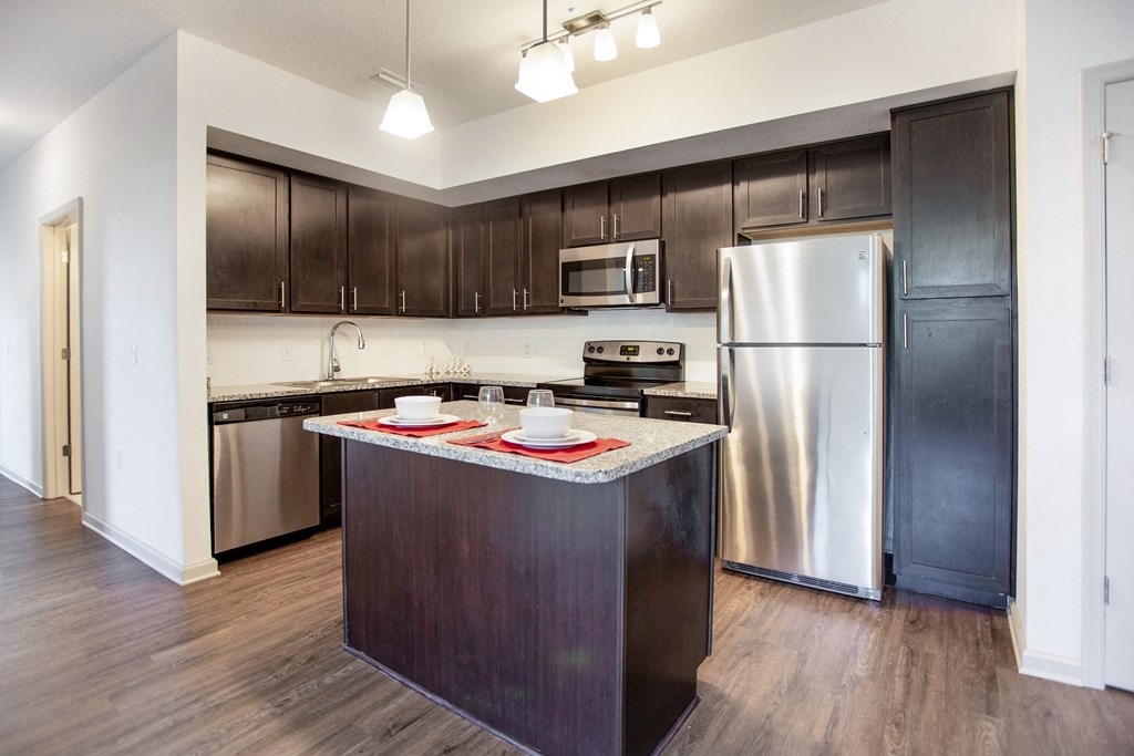 a kitchen with dark wood cabinets and stainless steel appliances