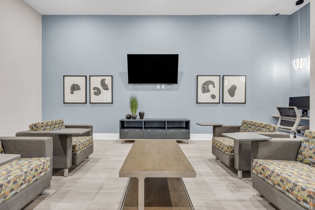 a living room with couches and tables and a television on the wall