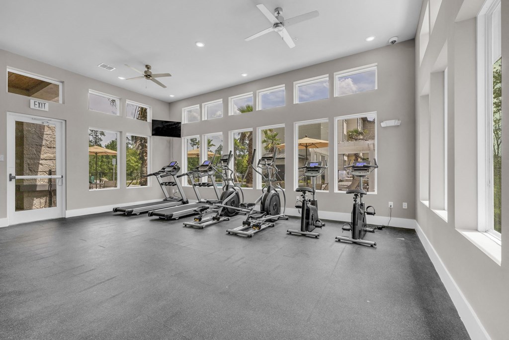 the gym has a large windowed room with treadmills and other exercise equipment