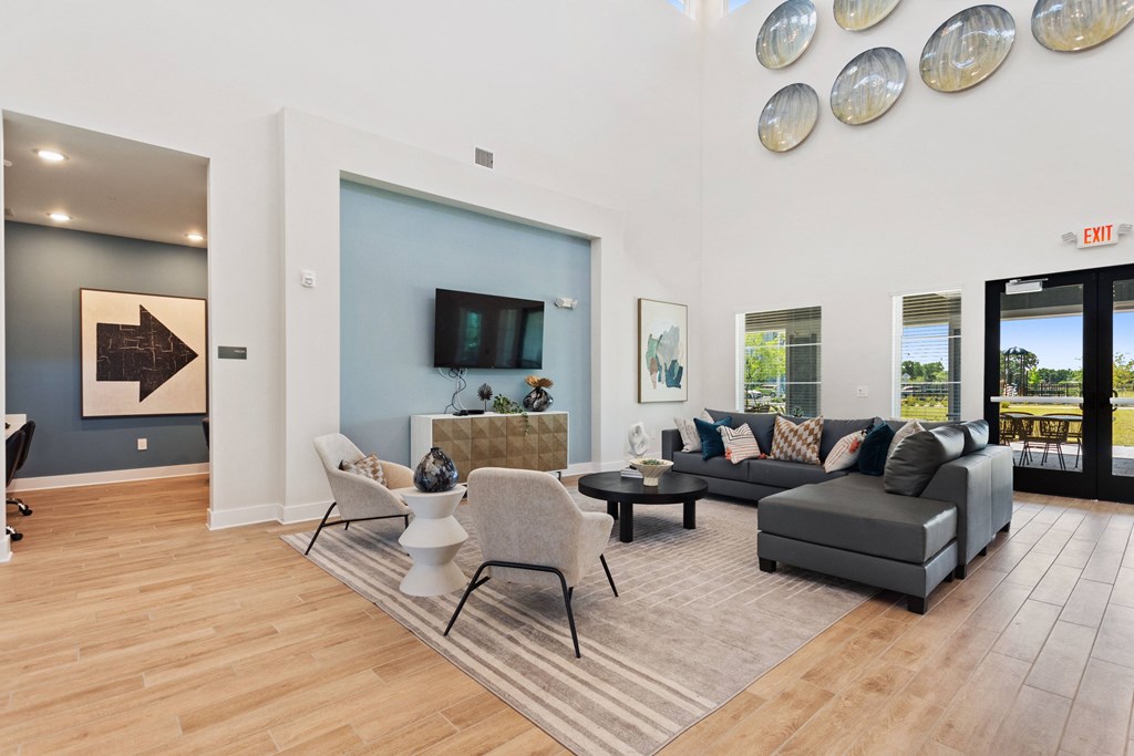 a living room with couches and chairs and a tv on the wall