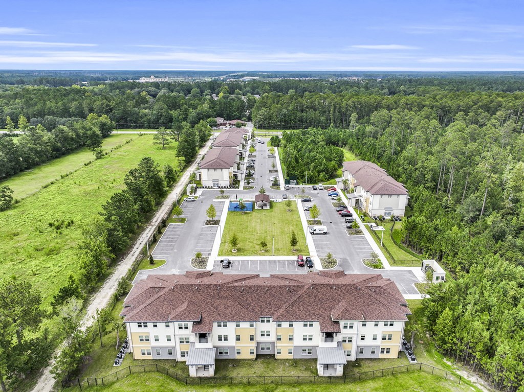 a birds eye view of a building surrounded by grass and trees