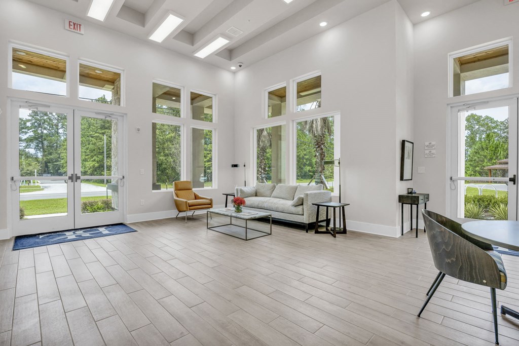 a living room with a couch and a table and windows