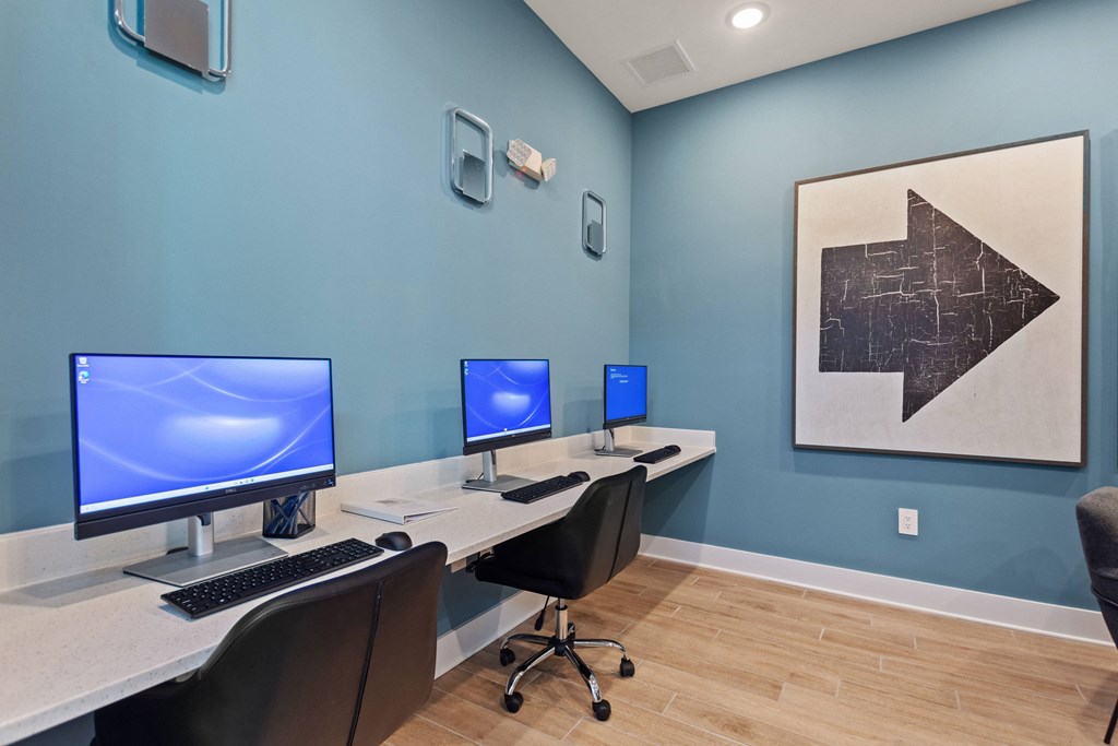 a home office with three computer monitors on a table